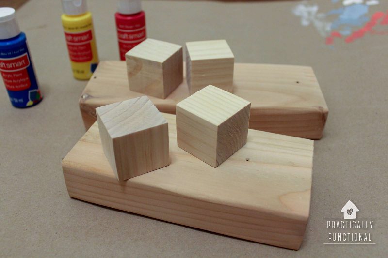 wooden cubes, paint, and 2 short wooden boards—supplies for making your own disney countdown clock