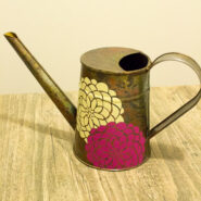 metal watering can decorated with yellow and purple flowers made with adhesive vinyl