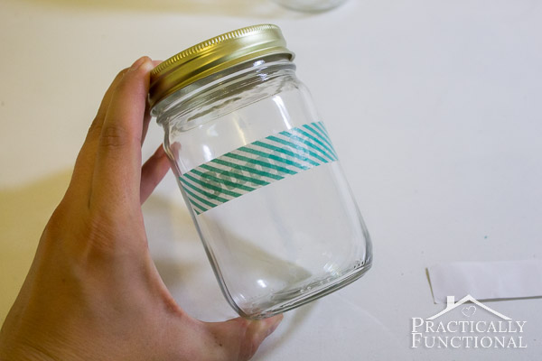 washi tape label being applied to mason jar using a piece of washi tape as transfer tape