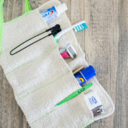 diy roll up toiletry bag made from a washcloth—laid open with toiletries and travel items in the pockets