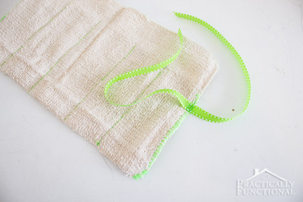 green ribbon attached to washcloth for diy roll up toiletry bag