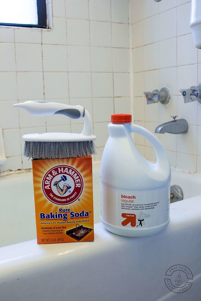 bottle of bleach, baking soda, and scrub brush sitting on the edge of a bathtub