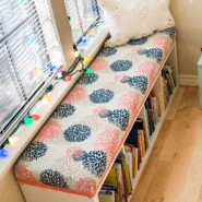 diy bench seat cushion on top of ikea kallax cubby storage unit being used as a window seat and book storage
