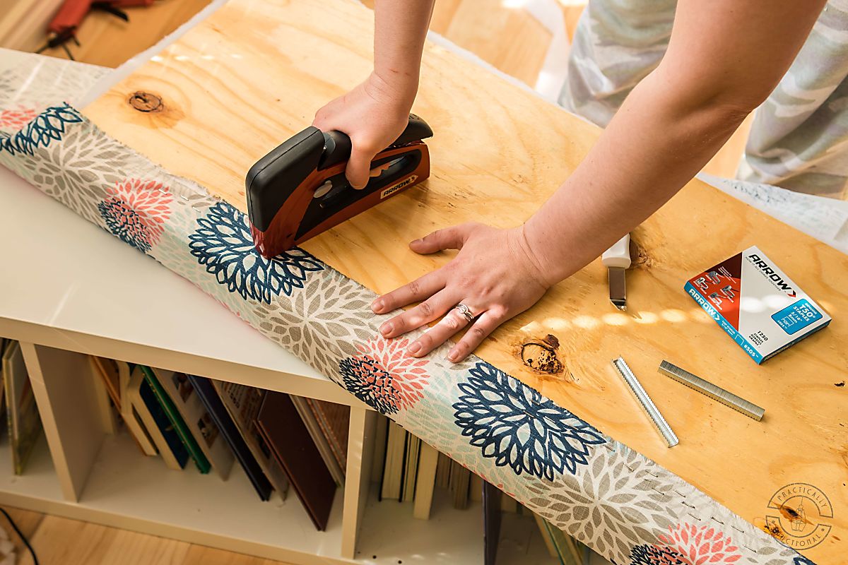 woman attaching upholstery fabric to diy bench cushion using arrow t50 red stapler